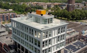 Modern gebouw met dakterras en omgeving