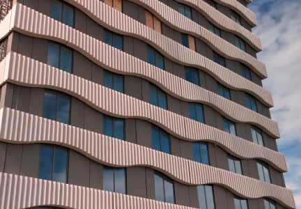 Golvend patroon op moderne gevel met ramen