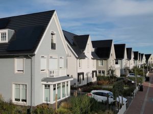 Rij moderne huizen met zonnepanelen in woonwijk.