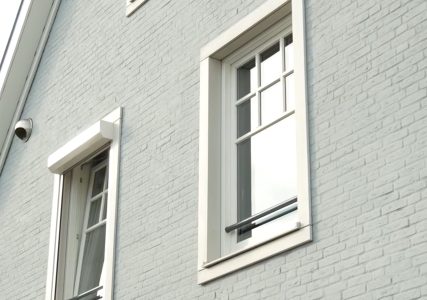 Grijs bakstenen gevel met twee ramen