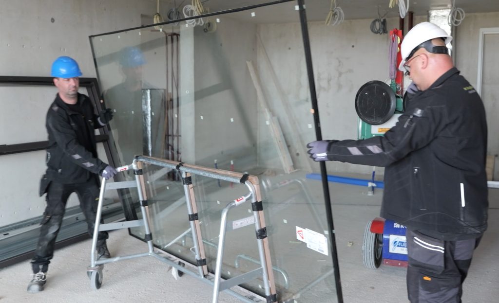 Werkers plaatsen groot glas in gebouw
