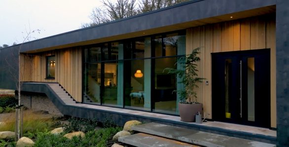 Moderne villa met grote ramen en houten gevel.