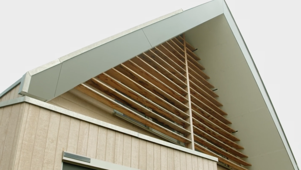 Houten gevel met horizontale lamellen en wit dak.